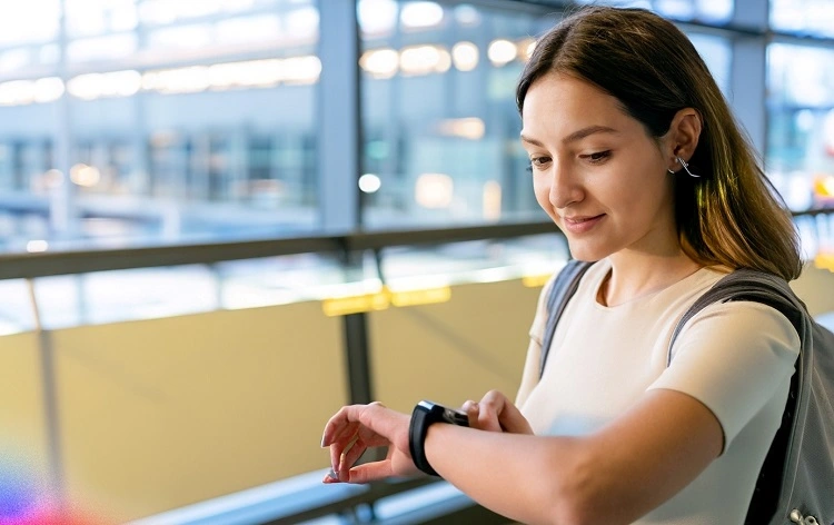 an-adult-girl-travelling-and-checking-her-smartwatch-in-airport